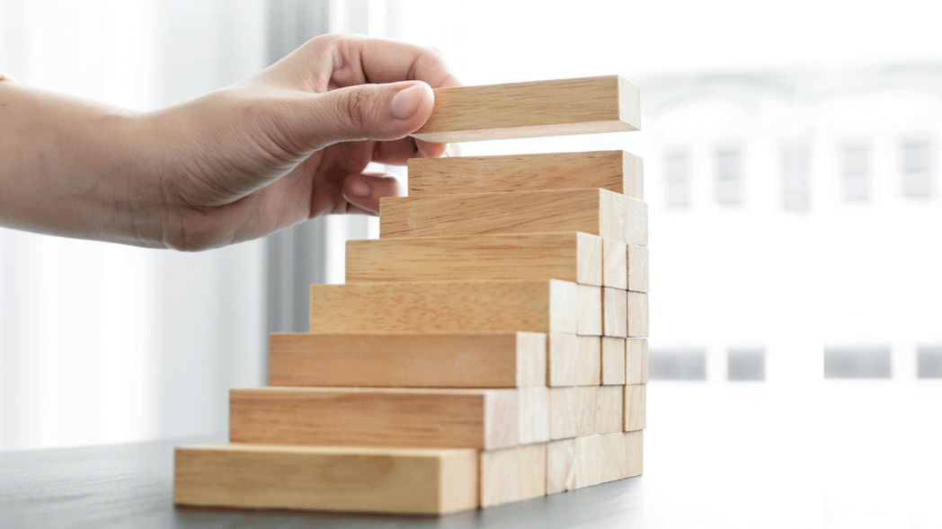 Photo of a person stacking pieces to illustrate the idea of ​​strategies to support the growth of the fashion brand