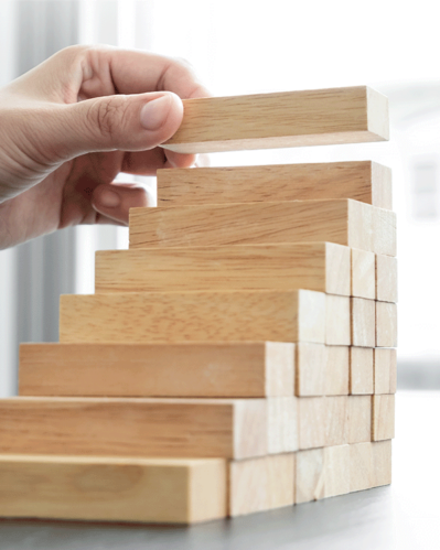 Photo of a person stacking pieces to illustrate the idea of ​​strategies to support the growth of the fashion brand