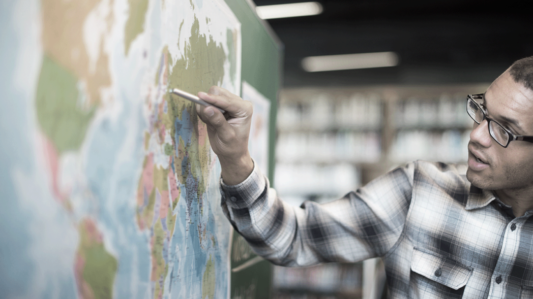 Photo of person pointing to a map illustrating the subject of the article on the challenges of international expansion.