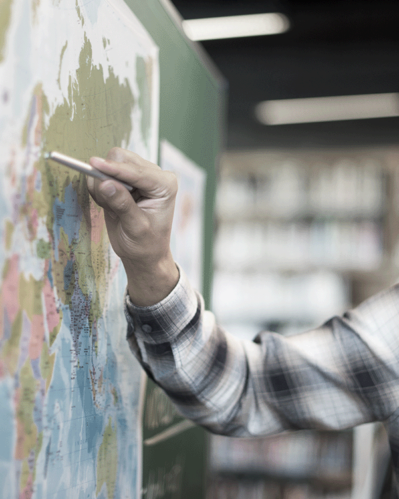 Photo of person pointing to a map illustrating the subject of the article on the challenges of international expansion.