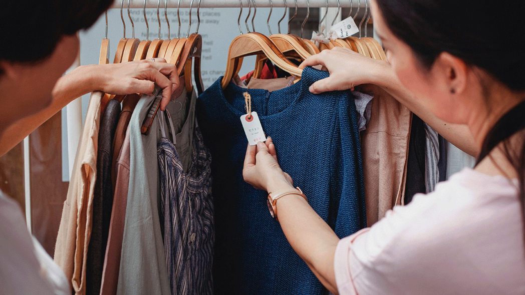 Photo of a person checking a clothing tag for the Tax ID Number