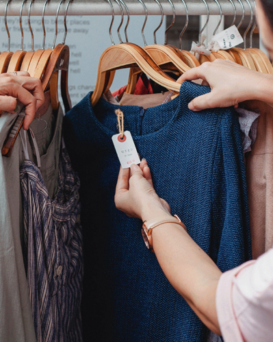 Photo of a person checking a clothing tag for the Tax ID Number
