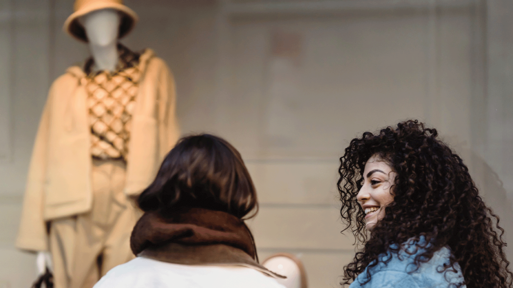 Photo of two women talking and a mannequin in front