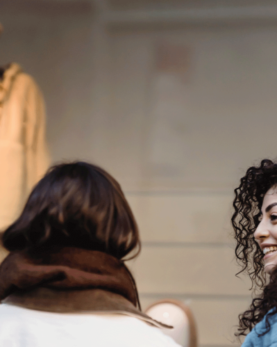 Photo of two women talking and a mannequin in front
