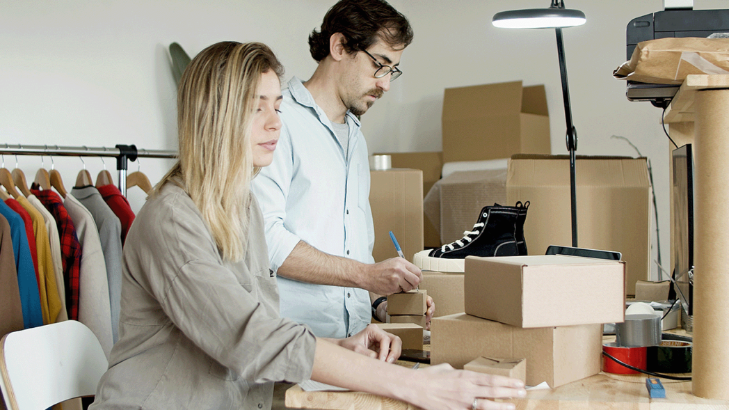 Photo of a woman and a man surrounded by shoeboxes